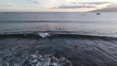 Areal-shot-of-surfer-catching-a-wave-at-sunset-in-Hawaii