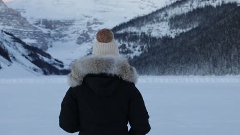 Mujer-Disfrutando-Del-Paisaje-Invernal,-Rodeada-De-Montañas-Y-Nieve,-Banff,-Tiro-A-Cámara-Lenta