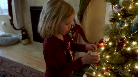 Entzückendes-Dreijähriges-Mädchen,-Das-Den-Weihnachtsbaum-Am-Kamin-Schmückt