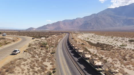Army-train-transporting-military-vehicles-and-tanks-by-rail-through-the-desert-in-the-United-States