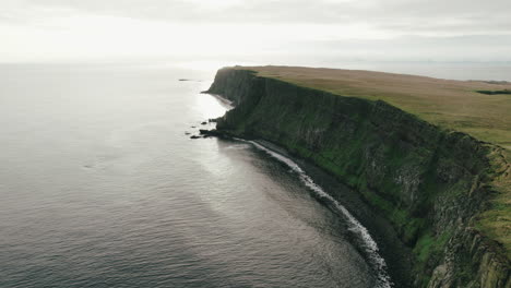 Slow-flyover-above-Atlantic-Ocean-along-cliffs-of-Grimsey-Island,-Arctic-Circle