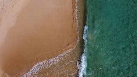 Closeup-shot-of-water-crashing-into-beach-from-the-sky