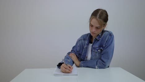 Frustrierte-Junge-Studentin,-Die-Versucht,-Notizen-Zu-Schreiben