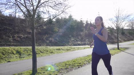 Fit-young-woman-running-in-Winter-sunshine-slow-motion-tracking