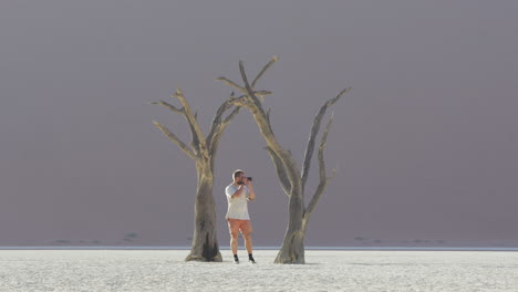 Photographer-With-Camera-Taking-Photos-At-Deadvlei,-Clay-Pan-In-Sossusvlei