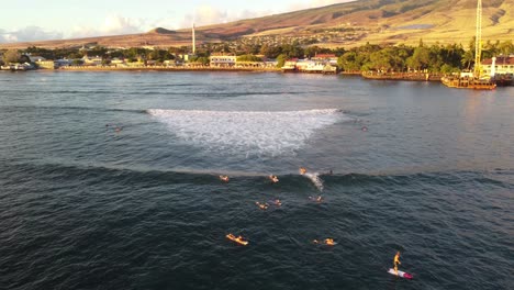 Surfers-waiting-and-catching-waves-in-Hawaii-with-a-view-of-Maui-in-the-back