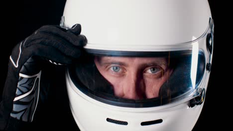 Man-with-strong-blue-eyes-looking-into-the-camera-and-closing-the-helmet-visor-in-4k-slow-motion