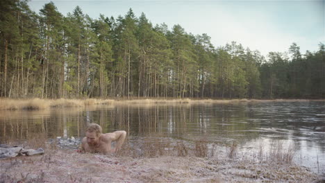 WIDE-SHOT---An-ice-bather-climbs-out-of-a-frozen-lake-following-his-routine