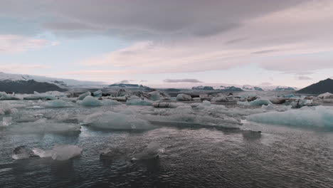 Slow-left-to-right-pan-of-icebergs-from-glacier-floating-Jokulsarlon-Lagoon,-Iceland