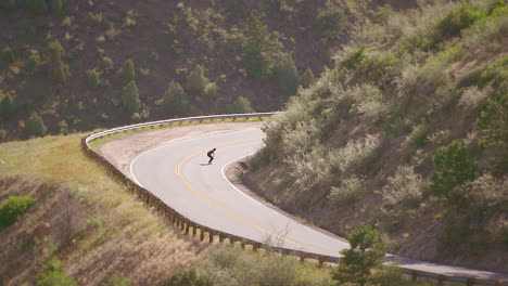 One-skateboarder-guy-bombing-a-steep-hill-in-Colorado-backcountry-on-a-skateboard