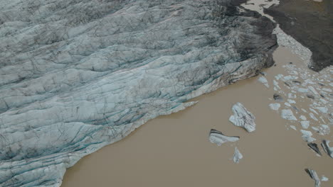 Aerial-parallax-above-Iceland-glacier-and-lake-brown-with-glacial-silt
