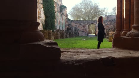Junges-Rothaariges-Mädchen,-Das-Die-Ruinen-Eines-Klosters-In-Spanien-Bewundert