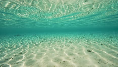 Beautiful-shot-of-reflecting-water-surface-underwater,-camera-below-water-of-a-tropical-beach-in-Fakarva,-second-biggest-atoll-in-French-Polynesia-in-the-south-pacific-ocean-in-Slow-motion