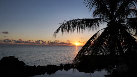 Long-shot-of-sunset-and-evening-sky-over-the-Lagoon-of-Fakarava,-French-Polynesia,-south-pacific-ocean-with-reflexions-on-the-calm-water-surface