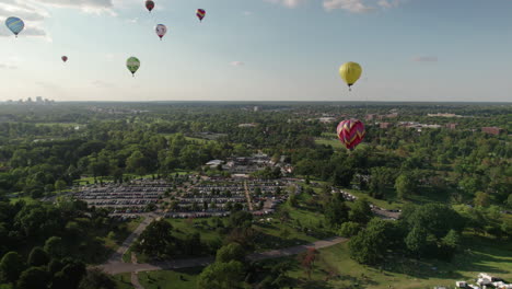 Flotte-Von-Heißluftballons,-Die-Anmutig-über-Den-Waldpark-Schweben,-St