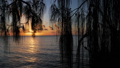 Kameraschwenk---Sonnenuntergang-Und-Abendhimmel-über-Der-Lagune-Von-Fakarava,-Französisch-Polynesien,-Südpazifik-Mit-Reflexionen-Auf-Der-Ruhigen-Wasseroberfläche