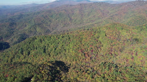 Cinematic-drone-shot-of-the-fall-colors-in-the-blue-ridge-mountains-in-North-Carolina,-with-Grandfather-mountain-in-the-distance
