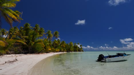 La-Playa-Tropical-Más-Hermosa-Del-Atolón-De-Fakarava,-Polinesia-Francesa-Con-Un-Barco-De-Pesca-Flotando-En-Las-Aguas-Cristalinas-De-La-Laguna-Azul