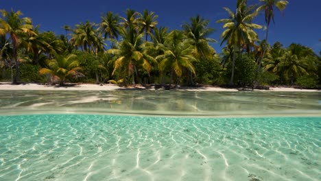 Split-Shot,-Halb-über,-Halb-Unter-Wasser-Eines-Tropischen-Strandes-In-Fakarva,-Dem-Zweitgrößten-Atoll-In-Französisch-Polynesien-Im-Südpazifik-In-Zeitlupe