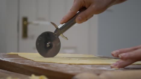Baker-Cutting-Flattened-Dough-With-Pizza-Cutter