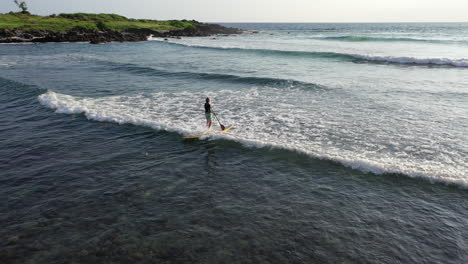 Aerial-view-of-a-paddleboarder-on-a-sup-board-paddling-in-the-ocean-in-the-waters-of-Reunion-Island