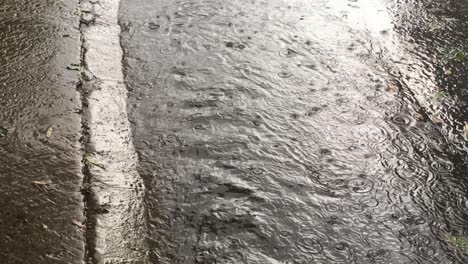 Un-Arroyo-Que-Corre-Sobre-El-Pavimento-En-Un-área-Urbana-Húmeda,-Como-Resultado-De-Fuertes-Lluvias-E-Inundaciones