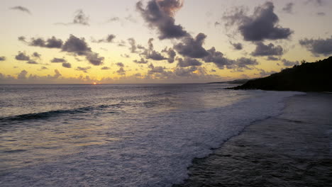 Luftaufnahme-Eines-Wunderschönen-Ozeansonnenuntergangs,-Während-Wellen-An-Einem-Strand-Brechen