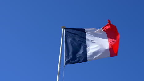 French-Flag-Flying-Against-Blue-Sky,-4K