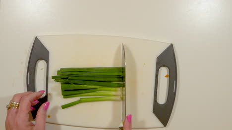 overhead-view-of-a-woman's-manicured-hands-chopping-green-onions