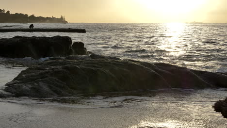 Serene-Rocky-Beach-at-Sunset,-Slow-Motion-Waves-4K