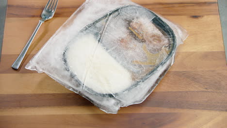Deep-frozen-chunk-piece-of-ice-on-a-healthy-meal-packed-box-container,-at-the-dining-table