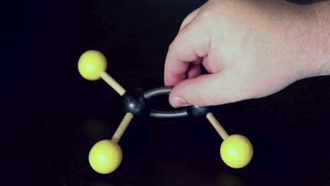 Ball-and-stick-model-of-ethene-with-a-double-bond-being-moved-around-on-a-black-lab-bench