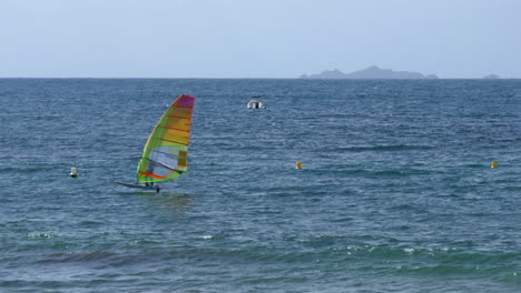 Windsurfer-Gliding-Across-Calm-Ocean-Surface,-Right-to-Left