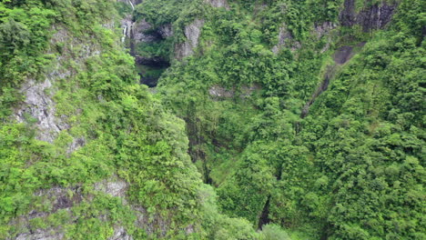Aerial-flight-over-vegetation-covered-mountains-to-reveal-the-Takamaka-waterfalls-on-Reunion-Island