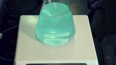 Close-up-of-blue-dilute-solution-of-copper-sulfate-in-erlenmeyer-flask-on-a-magnetic-stirrer