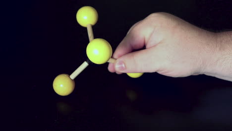Ball-and-stick-model-of-methane-being-moved-around-on-a-black-lab-bench