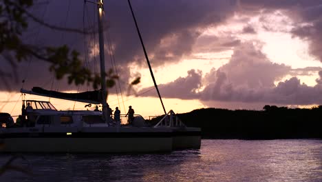 Large-catamaran-coming-into-shore-during-a-stunning-sunset-on-an-island-in-the-Caribbean