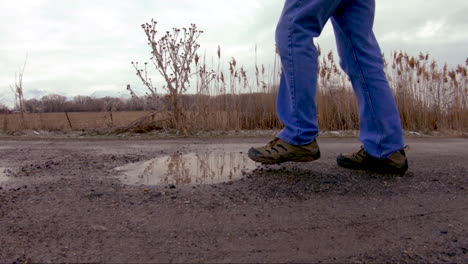 Close-up-of-a-puddle-that-a-man-steps-in-while-walking-by---slow-motion