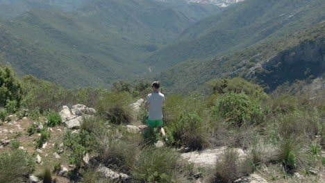 Drone-tracking-Scandinavian-male-tourist-while-filming-the-nature-around-La-Concha-in-Spain