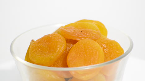 Transparent-bowl-with-Turkish-apricot-rotating-on-a-white-background