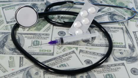 slow-sliding-shot-over-medical-items-lying-on-top-of-hundreds-of-US-Dollar-Bills