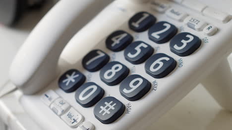 Close-up-of-a-man-dialling-999-on-a-telephone