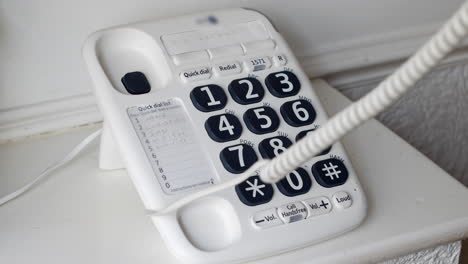 A-man-dialling-911-on-a-landline-telephone