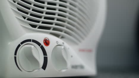 A-man-turning-off-a-fan-heater
