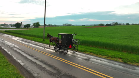 Low-aerial-tracking-shot-of-Amish-horse-and-buggy