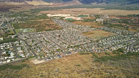 Aerial-view-of-Hawaiian-neighborhood-with-blue-sky-and-clouds-tilt-up
