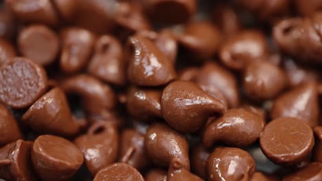 Pila-De-Chispas-De-Chocolate-Con-Leche-Caliente-Que-Brillan-En-Macro-De-Luz-De-Cerca-4k-Barrido-De-Luz-Y-Pan-A-La-Derecha