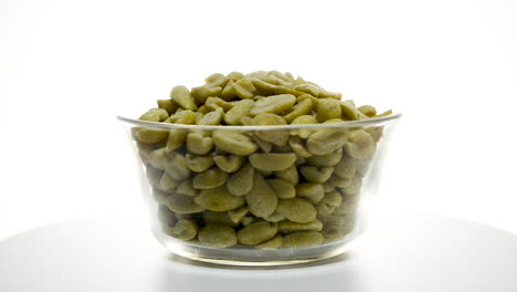 Glass-bowl-with-peanuts-rotating-on-a-white-background