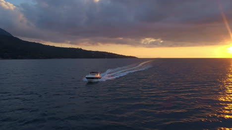 Aerial-parallax-shot-around-a-speed-boat-on-the-water-with-the-sunset-in-the-background