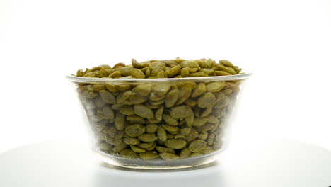 Glass-bowl-full-of-soya-beans-rotating-set-against-white-isolated-studio-background